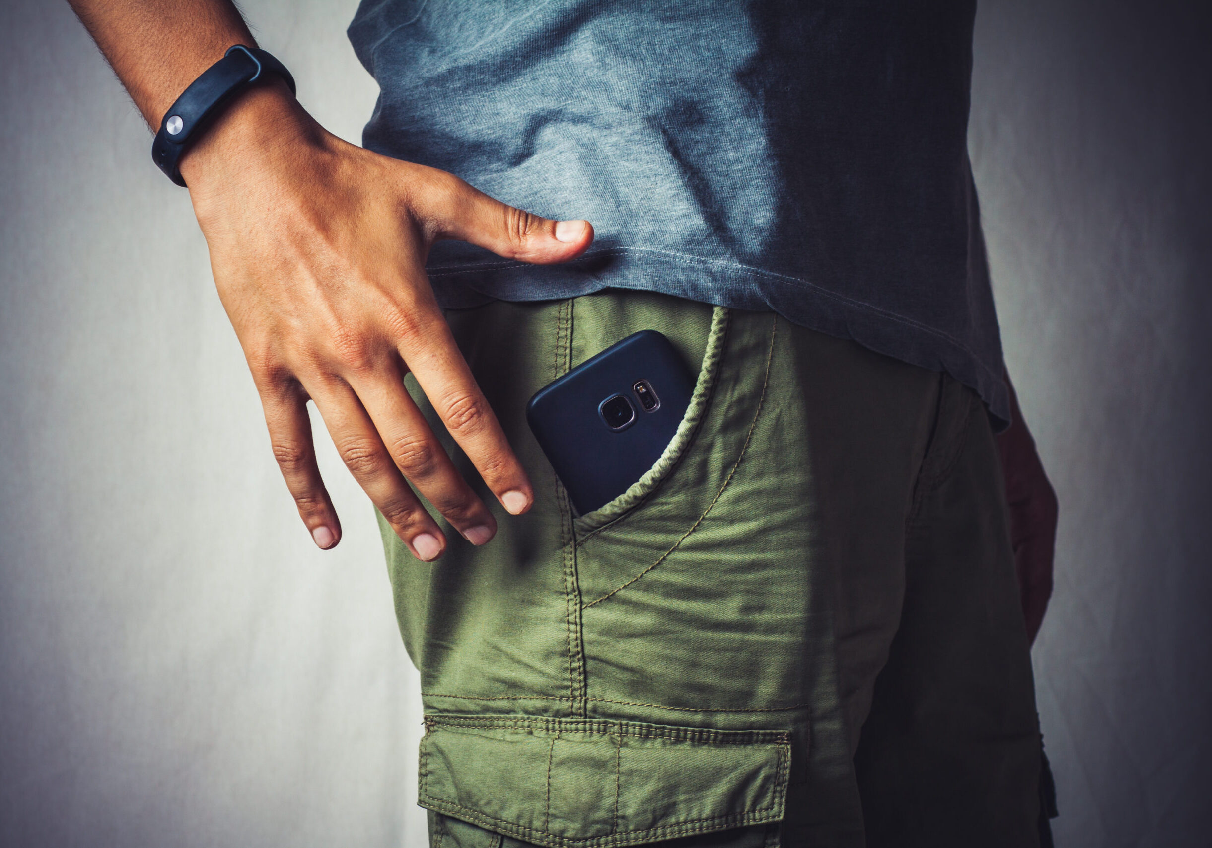 close-up of a hand about to taking a smart phone from a pant's pocket